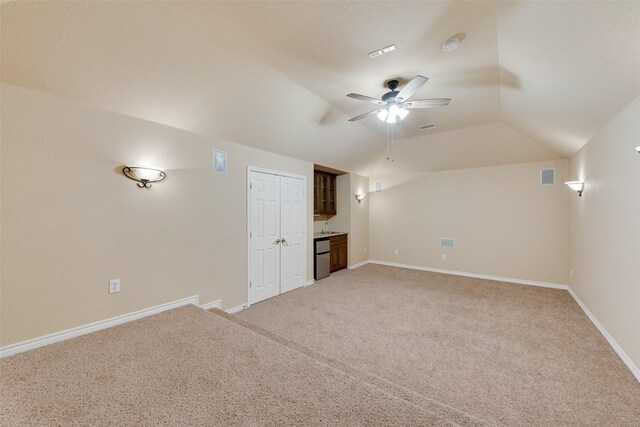 unfurnished living room featuring lofted ceiling, ceiling fan, and carpet floors