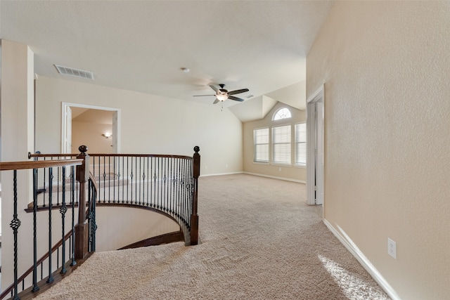 hall with carpet floors and vaulted ceiling