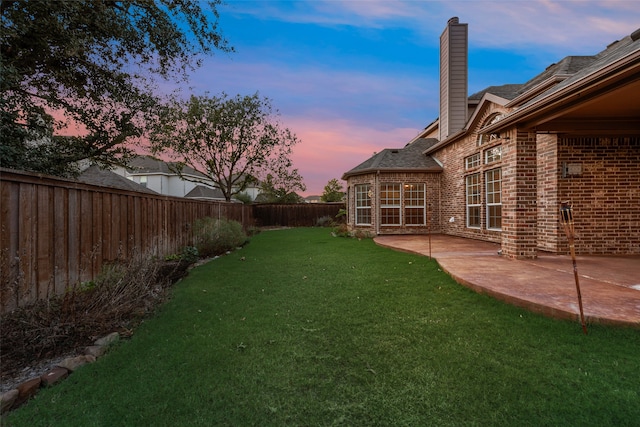 yard at dusk featuring a patio