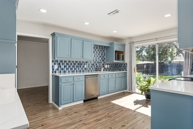 kitchen with blue cabinets, light wood-type flooring, premium range hood, and appliances with stainless steel finishes