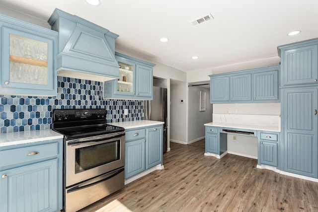 kitchen with backsplash, blue cabinets, sink, stainless steel dishwasher, and light wood-type flooring