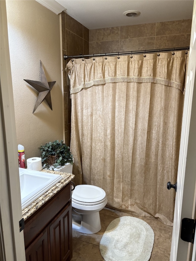 bathroom with a shower with curtain, tile patterned flooring, vanity, and toilet