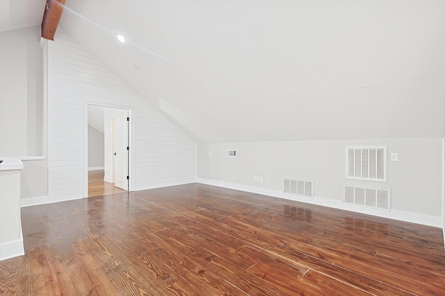 additional living space with wood-type flooring and vaulted ceiling with beams