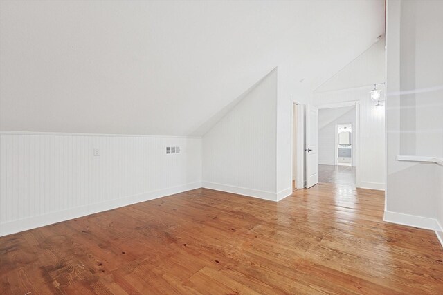 bonus room with light hardwood / wood-style floors and lofted ceiling