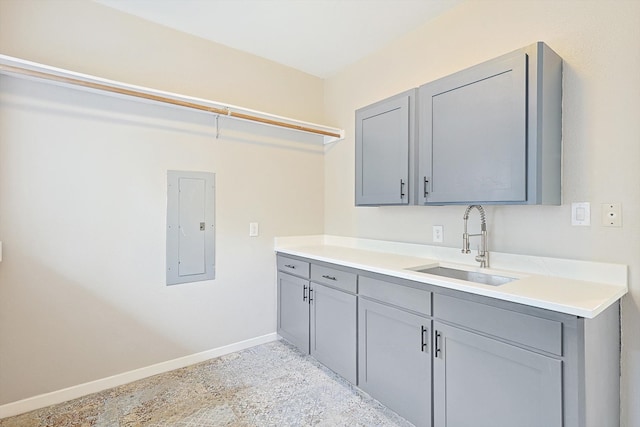 clothes washing area featuring electric panel and sink