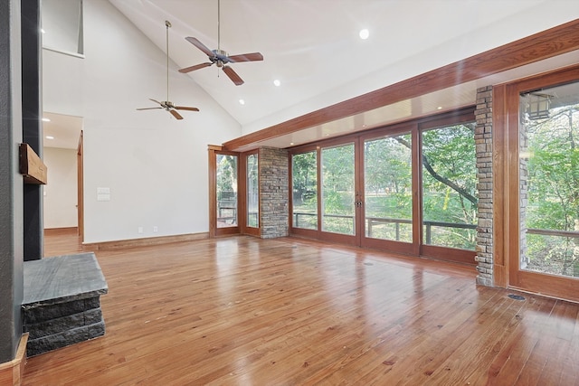 unfurnished living room featuring high vaulted ceiling, a wealth of natural light, ceiling fan, and light hardwood / wood-style flooring