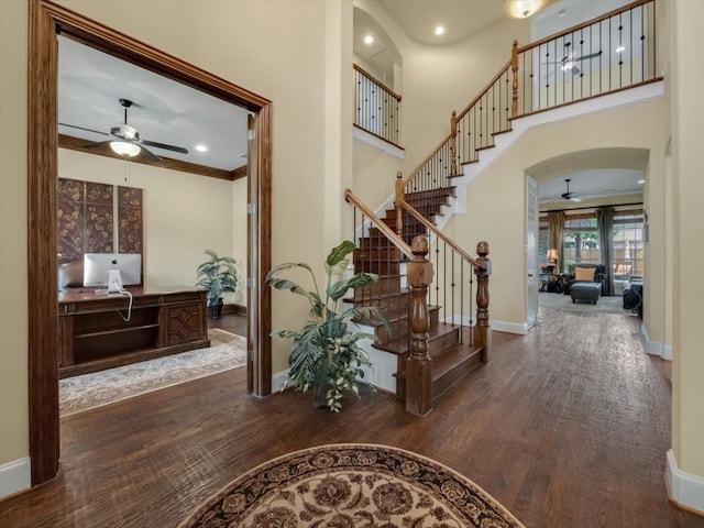 entrance foyer with ceiling fan, dark wood-type flooring, and ornamental molding