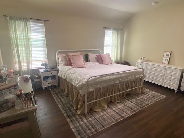 bedroom with dark hardwood / wood-style flooring, multiple windows, and lofted ceiling