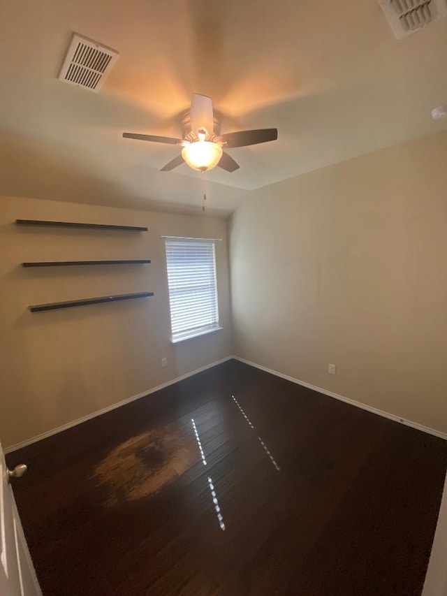 spare room with ceiling fan and dark hardwood / wood-style flooring