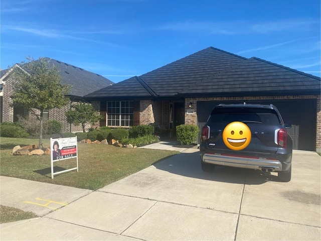 ranch-style house featuring a garage and a front lawn