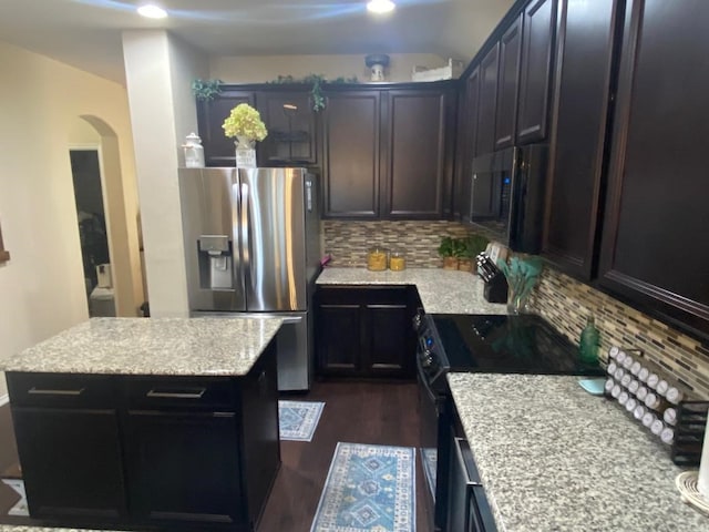 kitchen with a center island, stainless steel refrigerator with ice dispenser, light stone countertops, tasteful backsplash, and dark hardwood / wood-style flooring