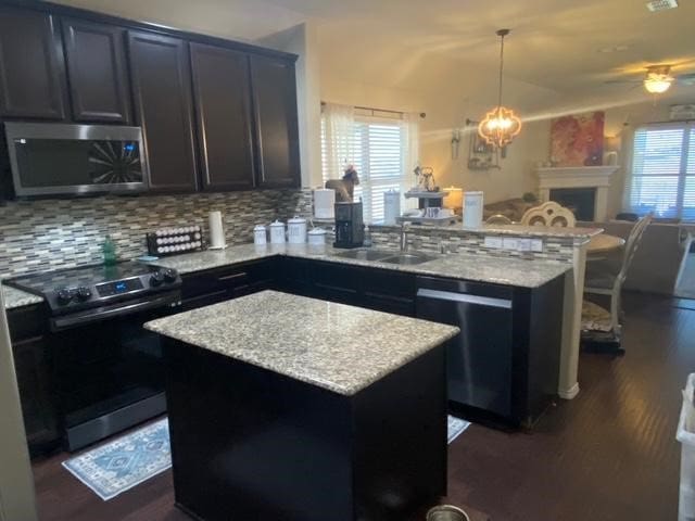 kitchen featuring plenty of natural light, a kitchen island, pendant lighting, and appliances with stainless steel finishes