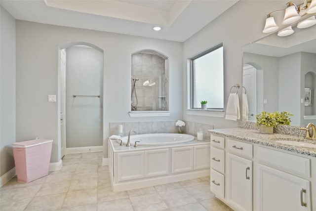 bathroom featuring plus walk in shower, vanity, and tile patterned floors