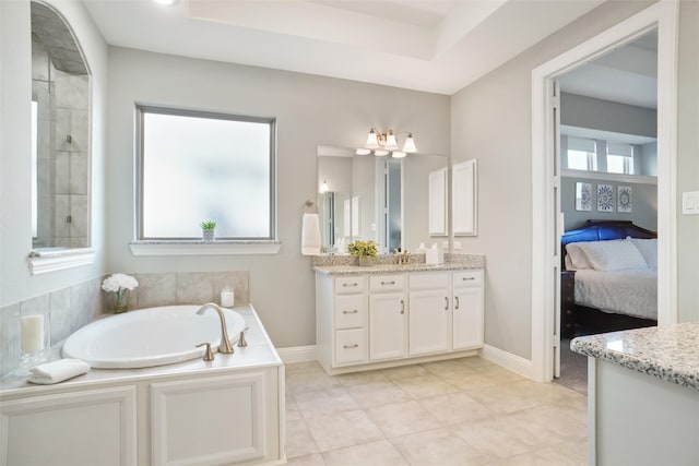 bathroom with a bathtub, vanity, and tile patterned floors