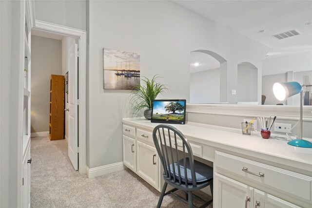 carpeted office space featuring built in desk