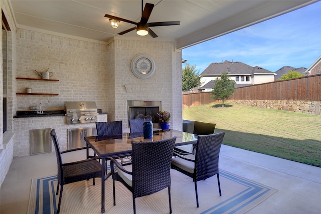 view of patio featuring an outdoor brick fireplace, grilling area, sink, and ceiling fan