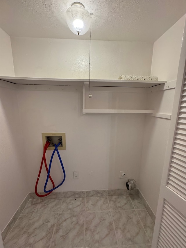 laundry room with washer hookup, a textured ceiling, and light tile patterned floors