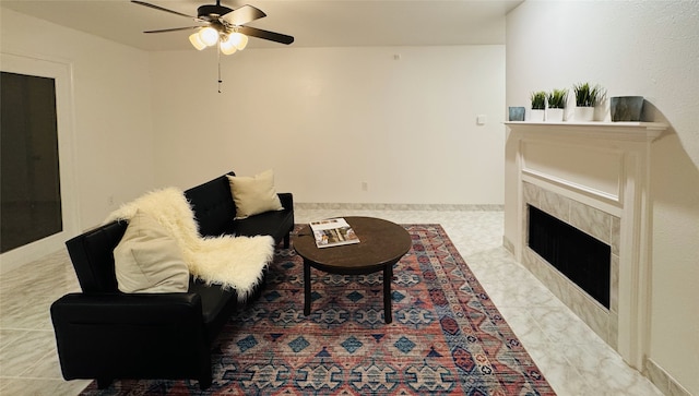 living room with a tiled fireplace and ceiling fan