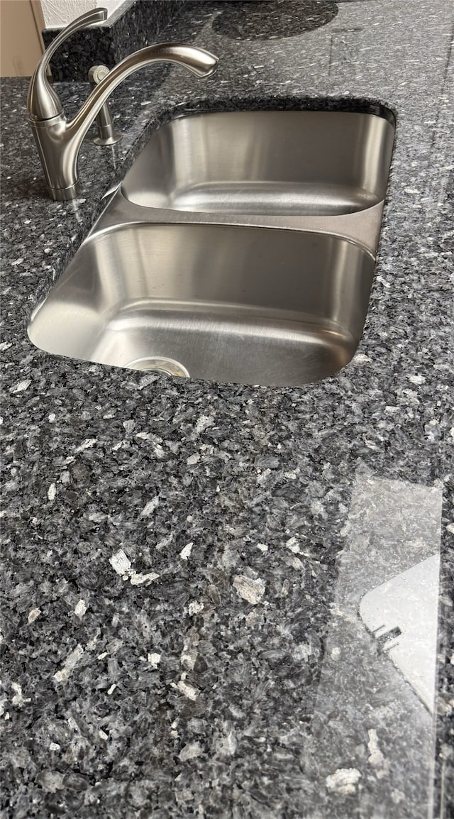 details featuring dark stone countertops and sink