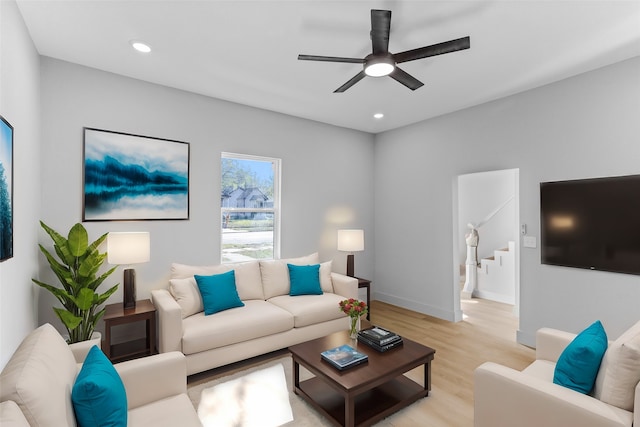 living area with light wood finished floors, recessed lighting, ceiling fan, baseboards, and stairs