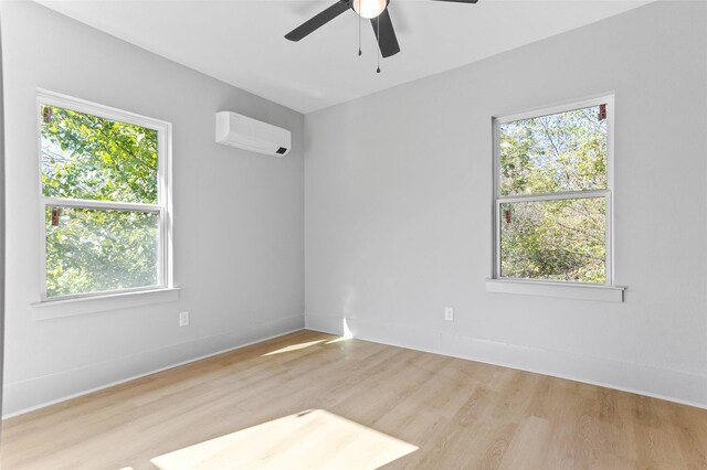 unfurnished room featuring ceiling fan, baseboards, wood finished floors, and a wall mounted air conditioner