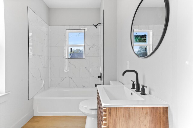 bathroom with toilet, shower / tub combination, wood finished floors, and vanity