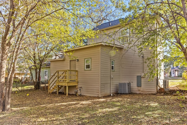 rear view of property featuring fence and central air condition unit