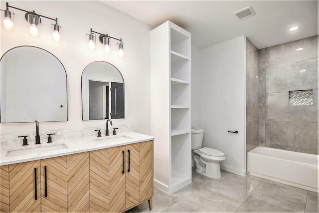 full bathroom with tile patterned floors, vanity, tiled shower / bath combo, and toilet