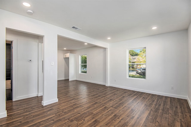 unfurnished room with plenty of natural light and dark wood-type flooring