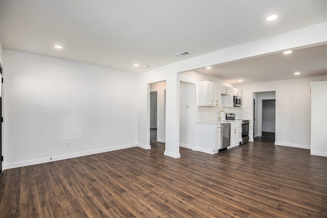 unfurnished living room featuring dark wood-type flooring and sink