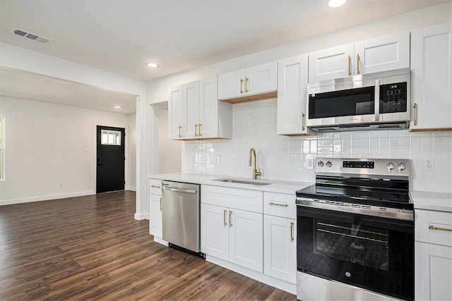 kitchen with sink, white cabinets, dark wood-type flooring, and appliances with stainless steel finishes