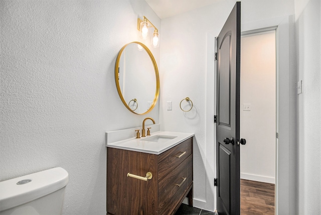 bathroom featuring hardwood / wood-style flooring, vanity, and toilet