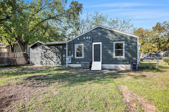 rear view of house with a yard and central AC unit