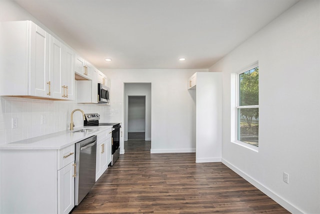 kitchen featuring tasteful backsplash, white cabinets, dark hardwood / wood-style floors, and appliances with stainless steel finishes