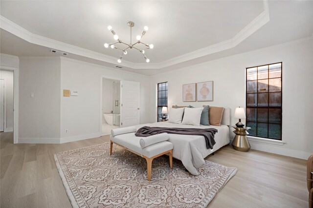 bedroom featuring a raised ceiling, ensuite bath, light hardwood / wood-style floors, and ornamental molding