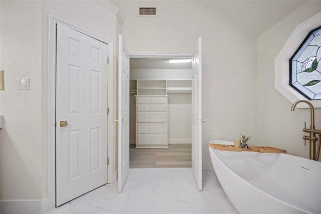 bathroom with a washtub and vaulted ceiling