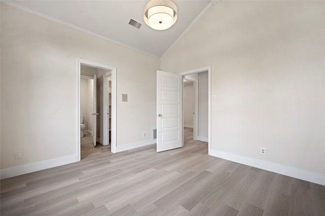 unfurnished bedroom with ensuite bathroom, light hardwood / wood-style flooring, and high vaulted ceiling