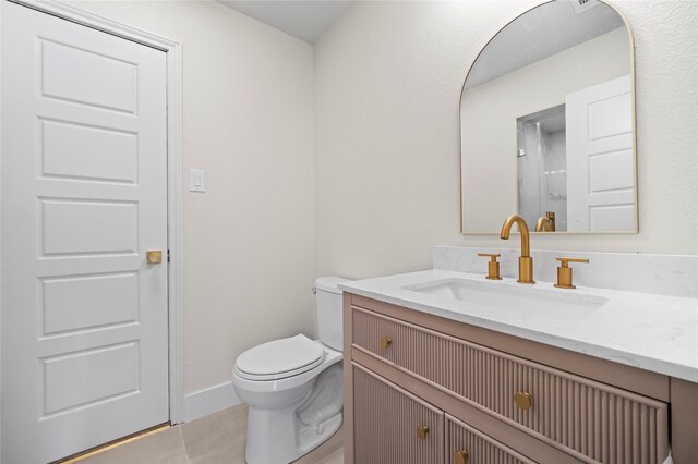 bathroom featuring tile patterned floors, vanity, and toilet