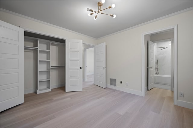 unfurnished bedroom featuring an inviting chandelier, ensuite bathroom, light hardwood / wood-style flooring, ornamental molding, and a closet