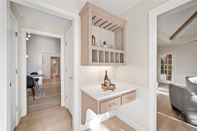 corridor featuring lofted ceiling, crown molding, and light hardwood / wood-style flooring