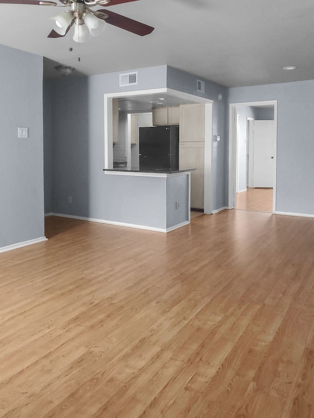 unfurnished living room with light wood-type flooring and ceiling fan