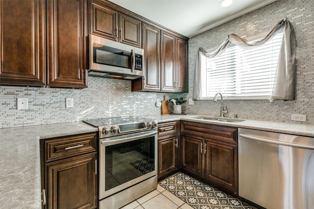 kitchen featuring dark brown cabinetry, appliances with stainless steel finishes, sink, and light tile patterned floors