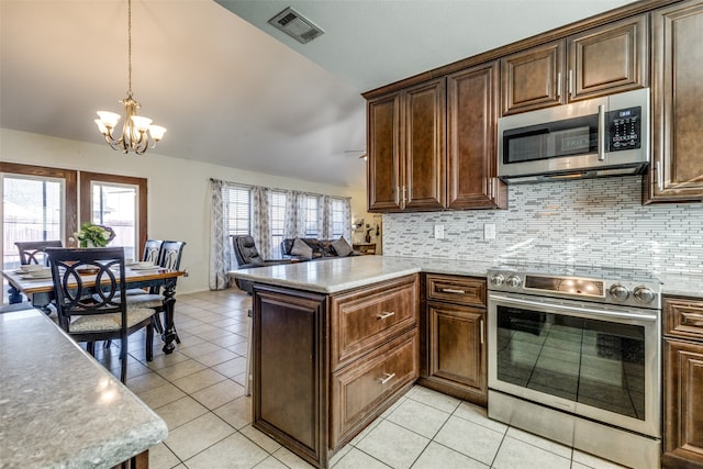 kitchen with kitchen peninsula, appliances with stainless steel finishes, light tile patterned floors, hanging light fixtures, and a notable chandelier