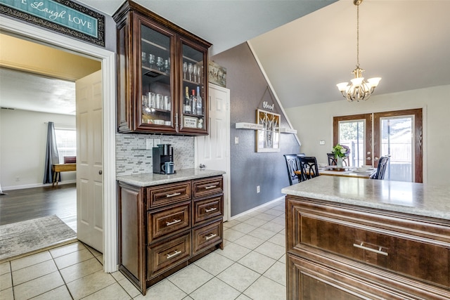 kitchen featuring dark brown cabinets, french doors, plenty of natural light, and decorative light fixtures