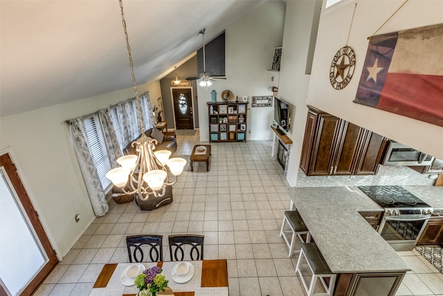 living room featuring high vaulted ceiling, light tile patterned floors, and ceiling fan with notable chandelier