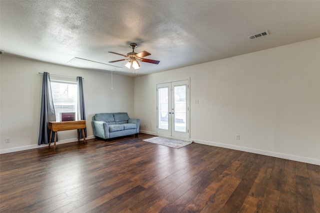 unfurnished room with dark wood-type flooring, a textured ceiling, ceiling fan, and french doors