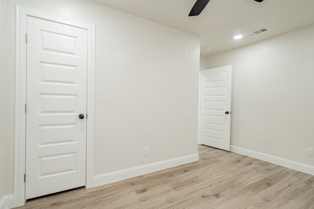 empty room with ceiling fan and light hardwood / wood-style floors