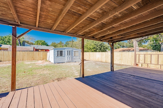 wooden terrace featuring a lawn and an outdoor structure