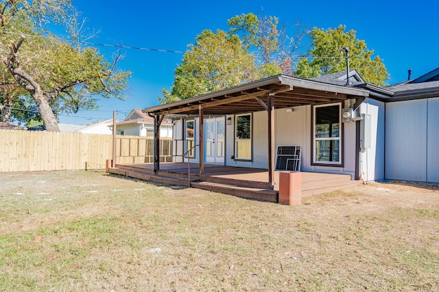 rear view of property featuring a deck and a lawn