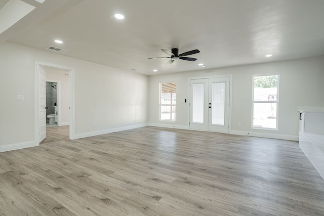 unfurnished living room with ceiling fan, light wood-type flooring, and a wealth of natural light